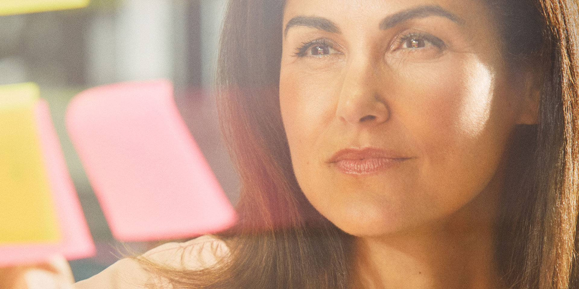 Wüstenrot Mitarbeiterin liest konzentriert ein Post-It auf einer Brainstorming-Wand